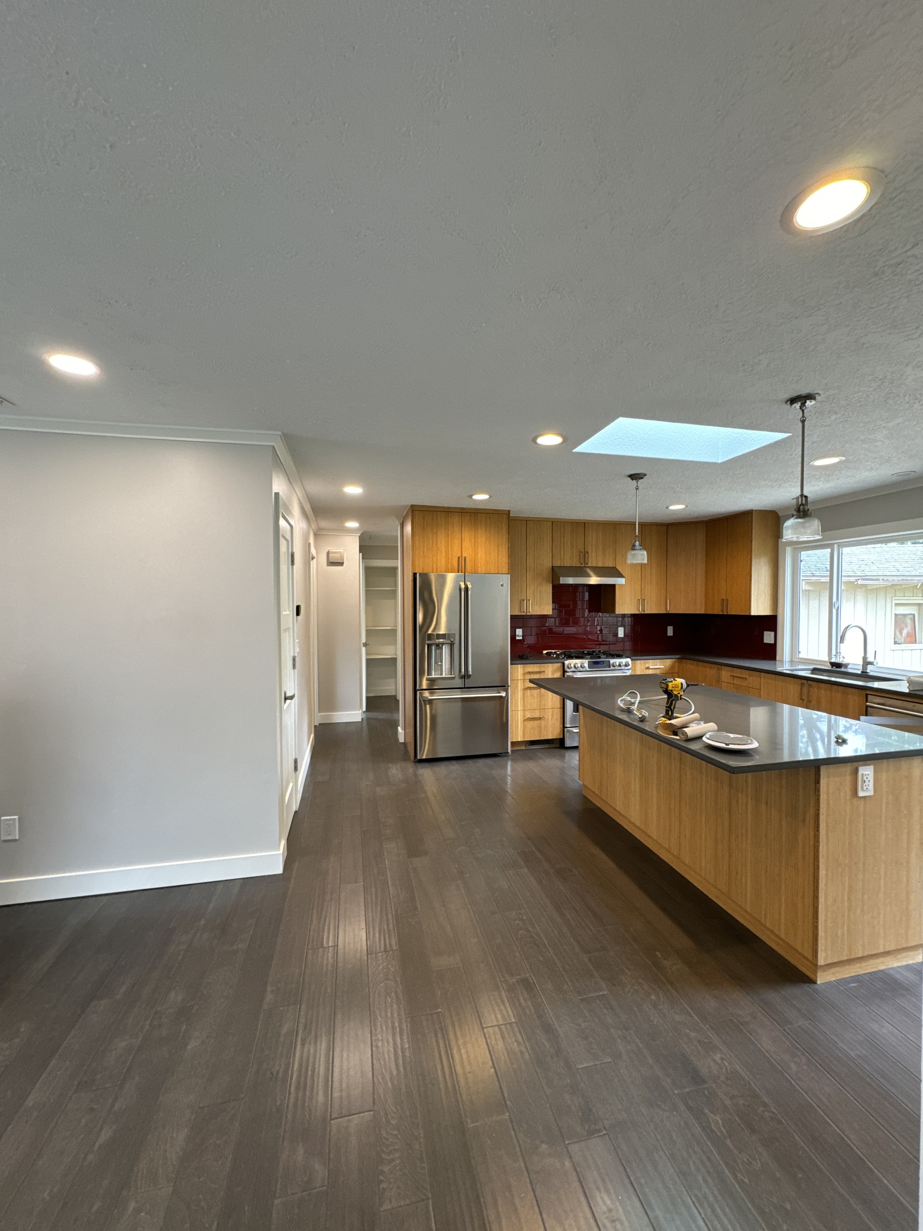 Kitchen remodel in progress with wood cabinetry, an island and tools on the countertop.