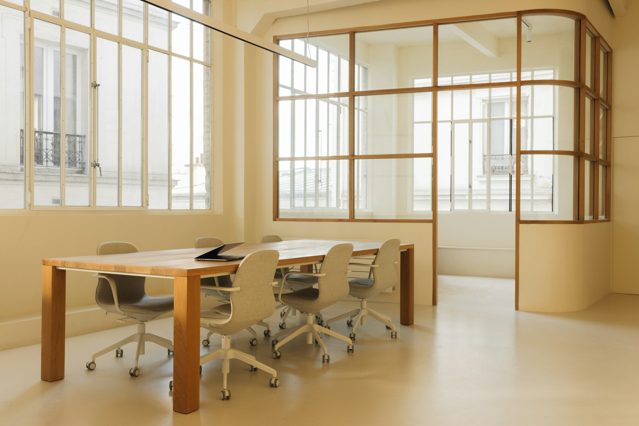 Light-filled studio meeting room with timber-framed glazing.