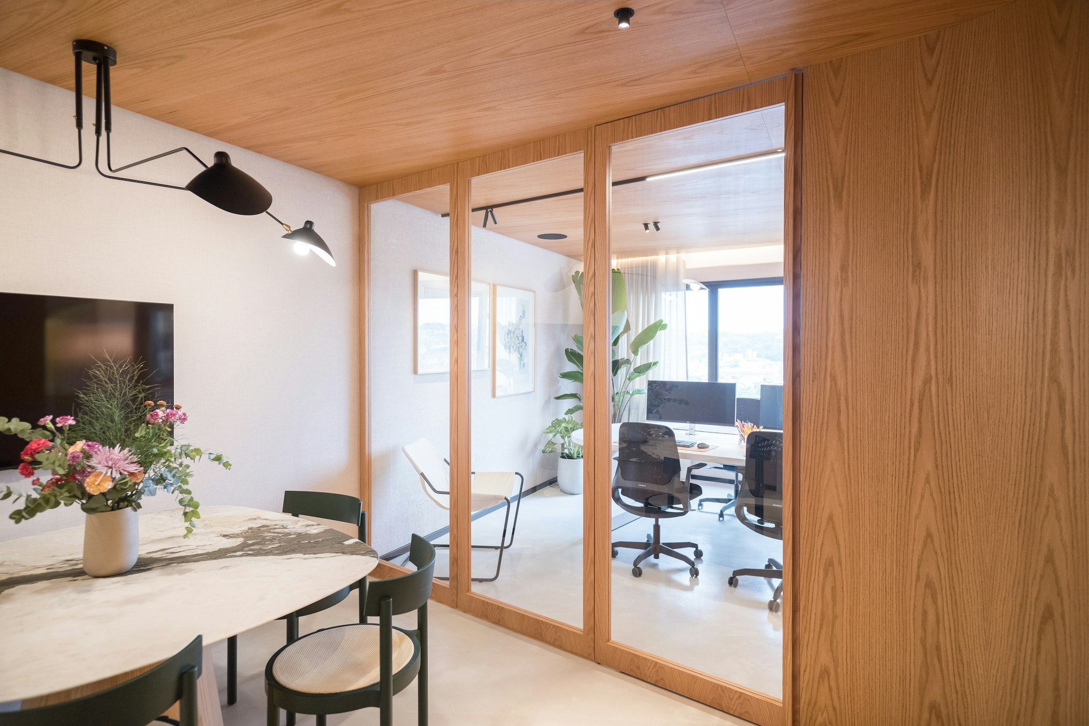 Workspace with a timber ceiling and glass-enclosed room.