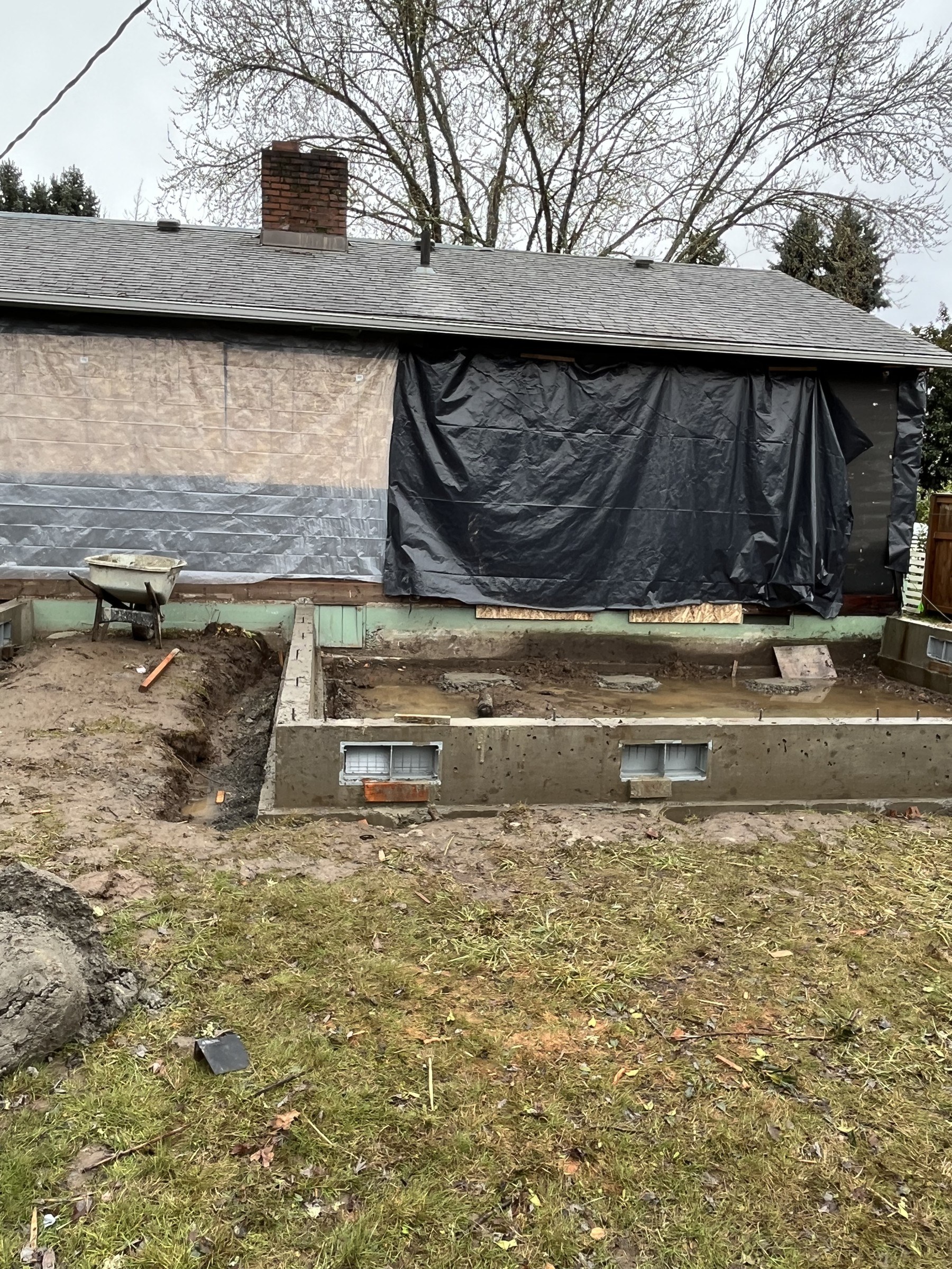 Foundation work in progress, with temporary protection at the house.