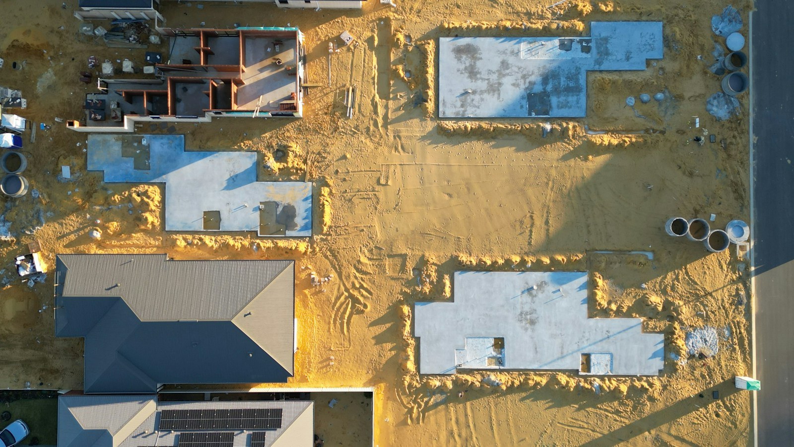 Aerial view of concrete house slabs during early residential construction.