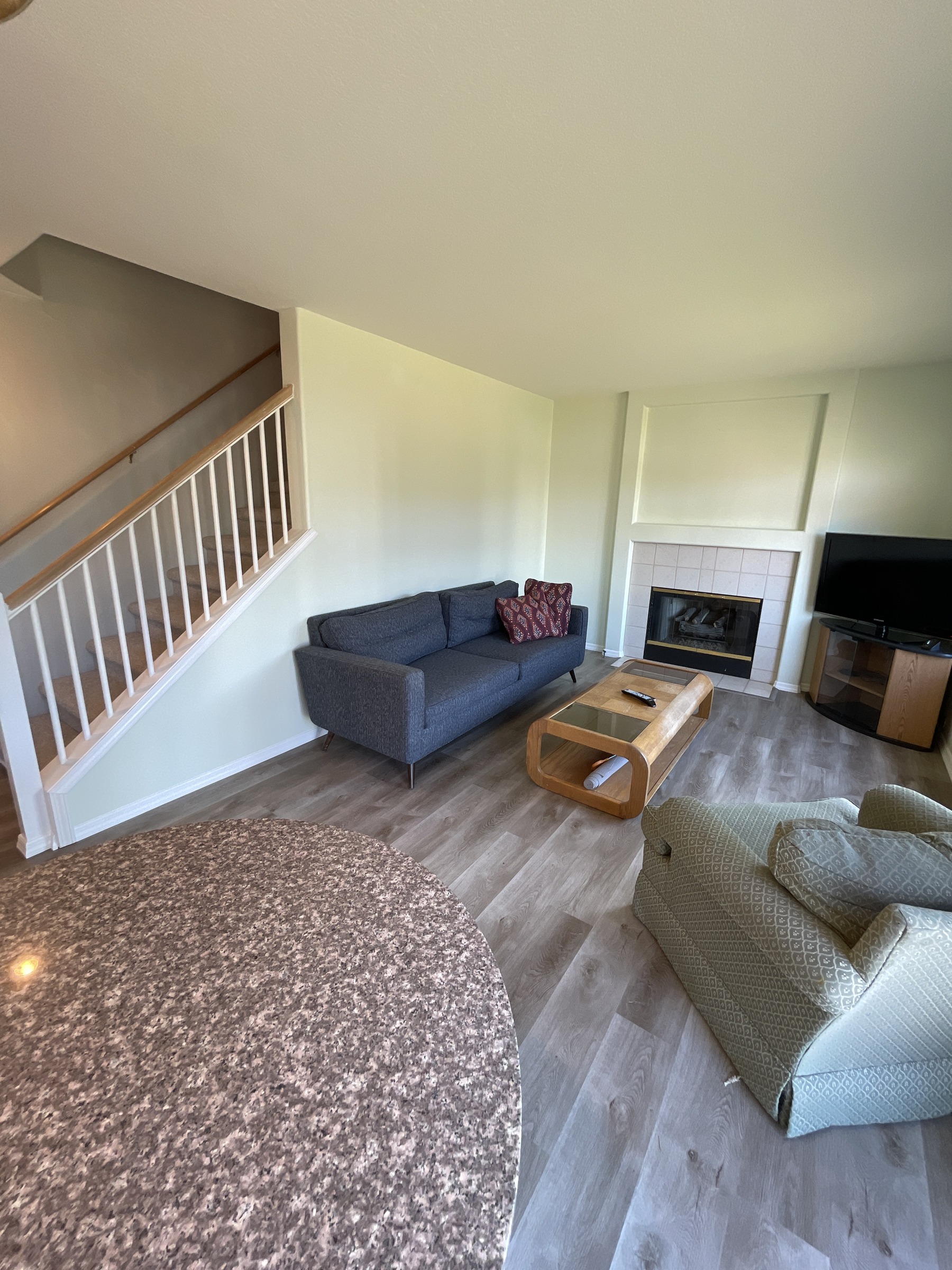 Connected living room with wood-look flooring, stairs, and seating