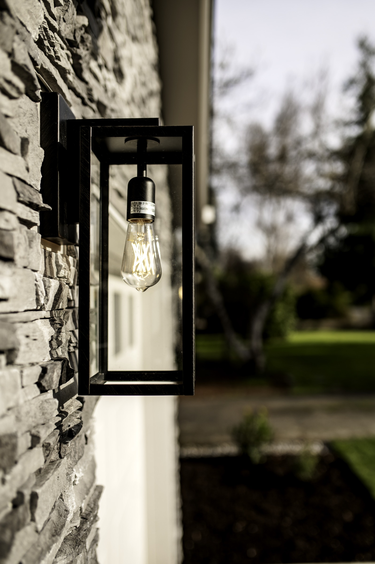 Black exterior lantern against textured stone cladding