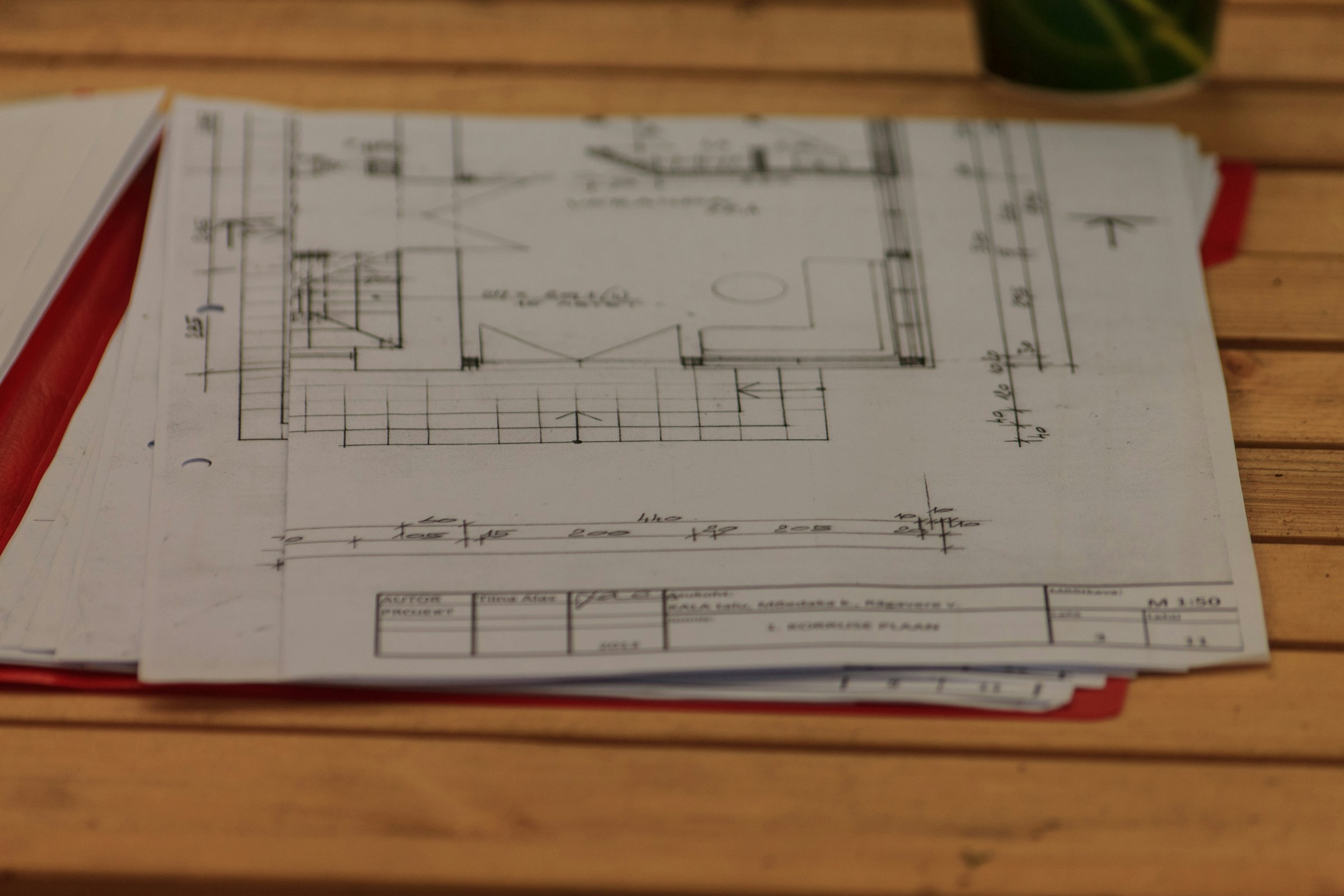 Printed architectural plans and a document folder on a table