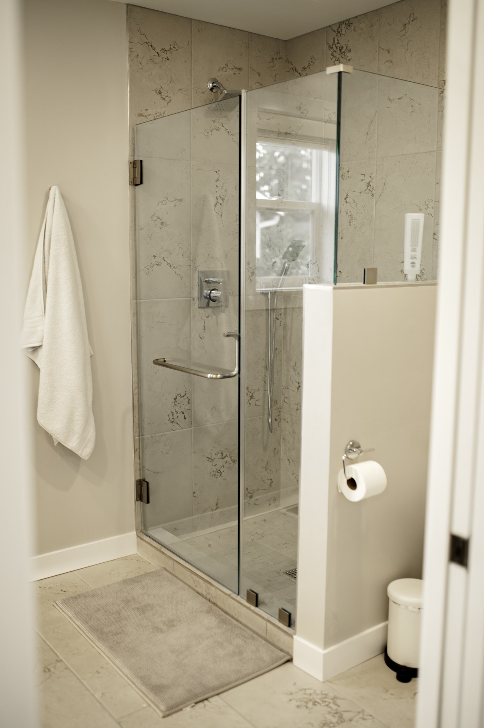 Resolution bathroom project with a glass-enclosed shower, light tile, and a tiled niche